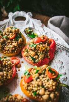 plate of vegan stuffed peppers with couscous and herbs