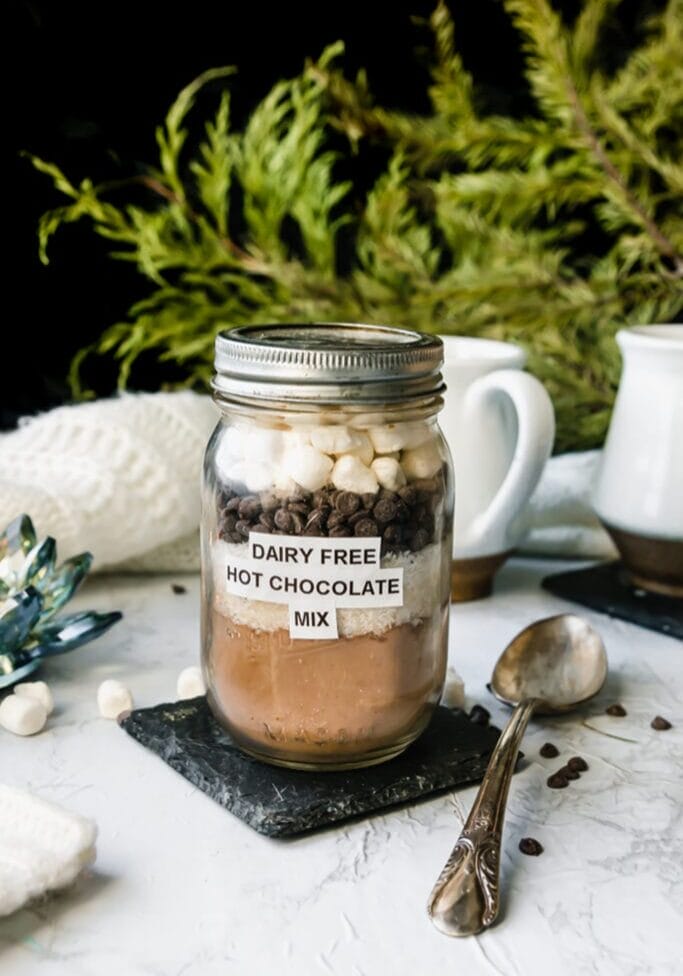mason jar filled with vegan hot cocoa mix, topped with chocolate chips and marshmallows