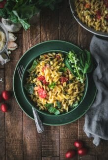 bowl of creamy sweet corn pasta with basil and tomatoes shot from overhead