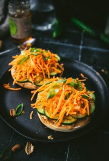 two pieces of Thai peanut bagel slices with carrots and cucumbers